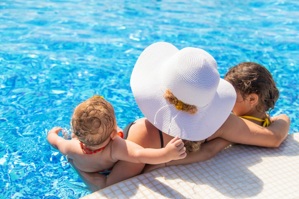 Mother with daughters in the pool. Selective focus.
